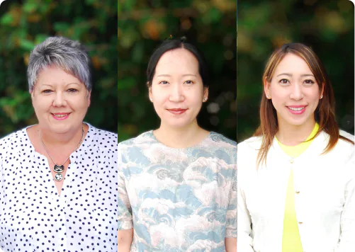 A photo of six international student care staff, all smiling, with greenery in the background.